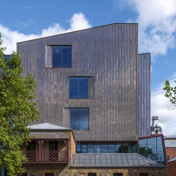 The copper clad Bendigo law Courts exterior is set amongst trees, in front of a blue sky.